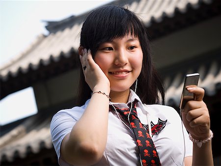simsearch:640-02775245,k - Teenage girl in school uniform smiling with mp3 player Stock Photo - Premium Royalty-Free, Code: 640-01645548
