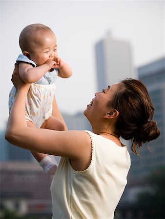 simsearch:640-01458949,k - Femme soulevant le bébé à l'extérieur et souriant Photographie de stock - Premium Libres de Droits, Code: 640-01645579