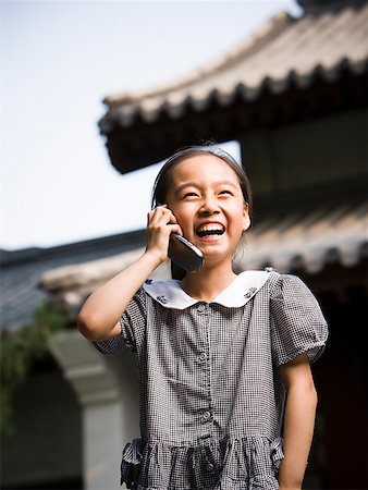 simsearch:640-01601405,k - Girl standing outdoors with cell phone in front of pagoda smiling Foto de stock - Royalty Free Premium, Número: 640-01645570