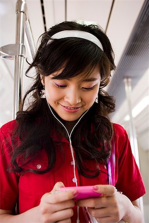 simsearch:640-02775245,k - Teenage girl listening to mp3 player smiling Stock Photo - Premium Royalty-Free, Code: 640-01645597