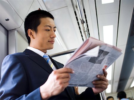 simsearch:640-02771261,k - Homme d'affaires sur le métro ou le bus avec journal souriant Photographie de stock - Premium Libres de Droits, Code: 640-01645591