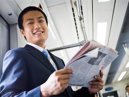 simsearch:640-02771261,k - Businessman on subway or bus with newspaper smiling Stock Photo - Premium Royalty-Free, Code: 640-01645592