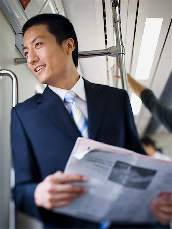 simsearch:640-02771261,k - Homme d'affaires sur le métro ou le bus avec journal souriant Photographie de stock - Premium Libres de Droits, Code: 640-01645593