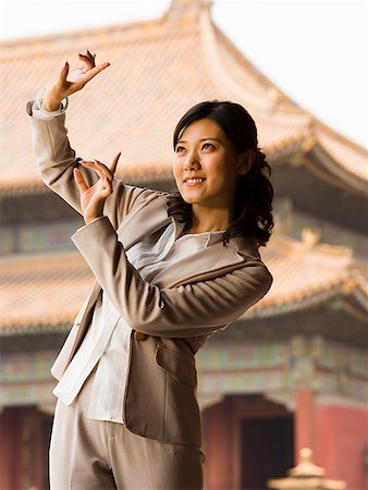 simsearch:640-01601473,k - Businesswoman doing tai chi outdoors smiling Foto de stock - Royalty Free Premium, Número: 640-01645640