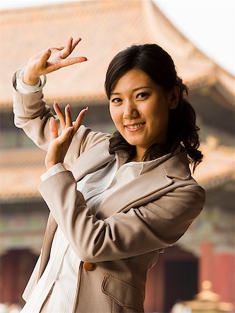 simsearch:640-01601473,k - Businesswoman doing tai chi outdoors smiling Foto de stock - Royalty Free Premium, Número: 640-01645641