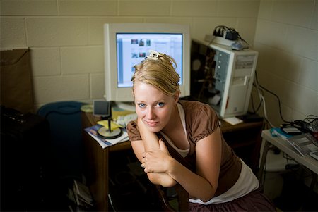 Woman sitting at desk with computer smiling Stock Photo - Premium Royalty-Free, Code: 640-01645672