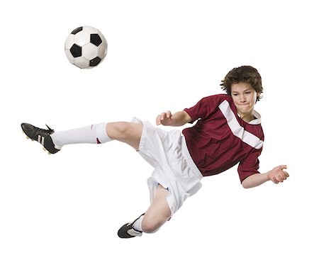 Young man kicking a soccer ball. Stock Photo - Premium Royalty-Free, Code: 640-02655784