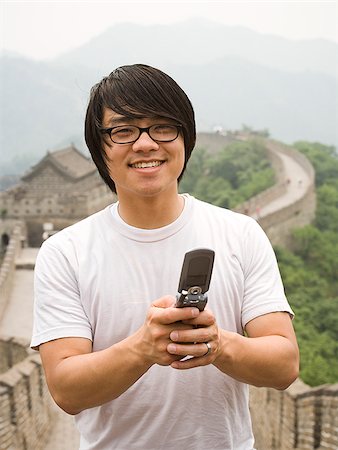simsearch:640-02776034,k - Junger Mann an der chinesischen Mauer auf einem Mobiltelefon. Stockbilder - Premium RF Lizenzfrei, Bildnummer: 640-02656235