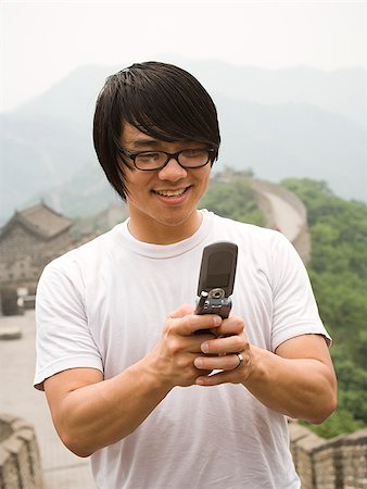 simsearch:640-02776034,k - Junger Mann an der chinesischen Mauer auf einem Mobiltelefon. Stockbilder - Premium RF Lizenzfrei, Bildnummer: 640-02656232
