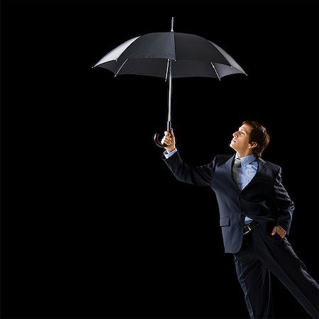 simsearch:640-02656983,k - Young man holding an umbrella. Foto de stock - Sin royalties Premium, Código: 640-02656982