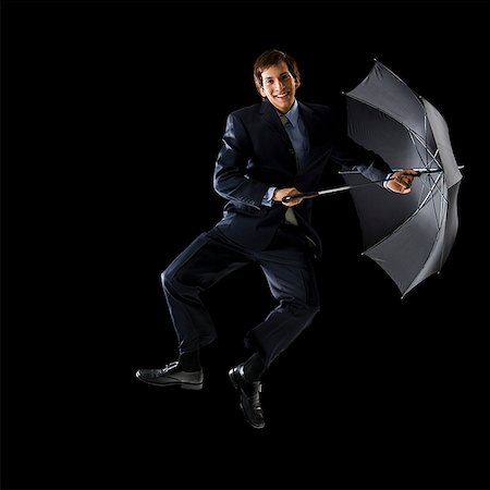 simsearch:640-02777685,k - Jeune homme tenant un parapluie et le saut. Photographie de stock - Premium Libres de Droits, Code: 640-02656983