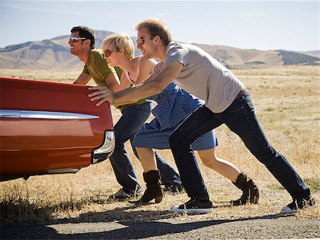 people pushing a car down the road Stock Photo - Premium Royalty-Free, Code: 640-02657603