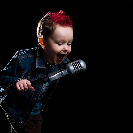 little boy singing into a microphone Foto de stock - Royalty Free Premium, Número: 640-02658866