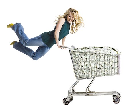 excited money - woman with a shopping cart full of money Stock Photo - Premium Royalty-Free, Code: 640-02659290