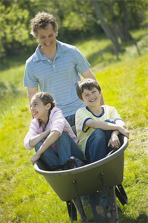 simsearch:685-03082700,k - Man pushing his son and daughter in a wheelbarrow Stock Photo - Premium Royalty-Free, Code: 640-02764644
