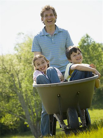 simsearch:685-03082700,k - Man pushing his son and daughter in a wheelbarrow Stock Photo - Premium Royalty-Free, Code: 640-02764645