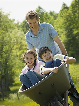 simsearch:685-03082700,k - Man pushing his son and daughter in a wheelbarrow Stock Photo - Premium Royalty-Free, Code: 640-02764646