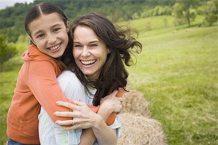 Portrait of a girl hugging her mother from behind Stock Photo - Premium Royalty-Free, Code: 640-02764693