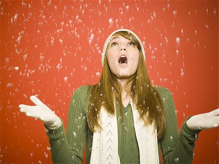 Woman looking up at snow falling Stock Photo - Premium Royalty-Free, Code: 640-02765045