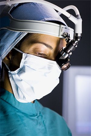 Female doctor in scrubs with head light in surgery Stock Photo - Premium Royalty-Free, Code: 640-02765078
