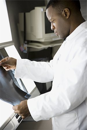 doctor looking at xray - Male doctor looking at chest x-rays Stock Photo - Premium Royalty-Free, Code: 640-02765080