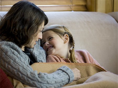 simsearch:640-02771500,k - Woman with young girl snuggling on sofa Foto de stock - Sin royalties Premium, Código: 640-02765108