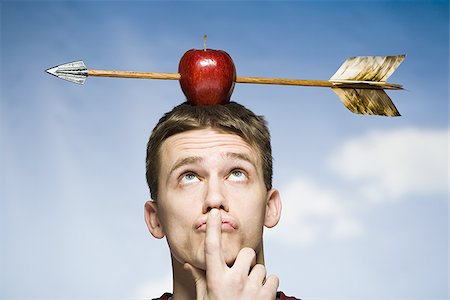 Man outdoors with arrow through red apple on head Stock Photo - Premium Royalty-Free, Code: 640-02765178