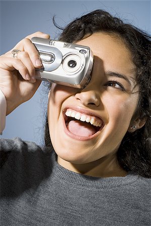 simsearch:640-03255699,k - Woman taking a photo with digital camera smiling Foto de stock - Sin royalties Premium, Código: 640-02765186