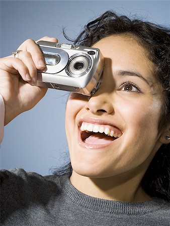 simsearch:640-03255699,k - Woman taking a photo with digital camera smiling Foto de stock - Sin royalties Premium, Código: 640-02765183