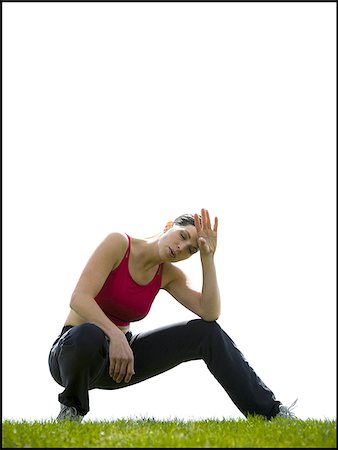 Woman wiping brow and taking a break from exercise on grass Stock Photo - Premium Royalty-Free, Code: 640-02765213