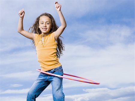 simsearch:640-02773934,k - Girl playing with hula hoop outdoors laughing Foto de stock - Royalty Free Premium, Número: 640-02765247