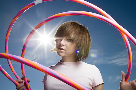 Portrait of a teenage girl holding hula hoops Stock Photo - Premium Royalty-Free, Code: 640-02765876