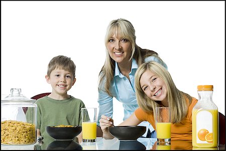 Portrait of a mid adult woman and her two children at the breakfast table Stock Photo - Premium Royalty-Free, Code: 640-02765947