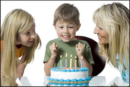 Close-up of a mother and her two children in front of a birthday cake Stock Photo - Premium Royalty-Free, Code: 640-02765940