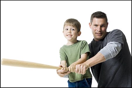 Portrait of a father teaching his son how to swing a baseball bat Stock Photo - Premium Royalty-Free, Code: 640-02765955