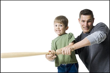 Portrait of a father teaching his son how to swing a baseball bat Stock Photo - Premium Royalty-Free, Code: 640-02765956