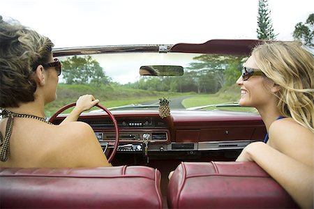 Close-up of two young women wearing sunglasses driving a car Stock Photo - Premium Royalty-Free, Code: 640-02766276