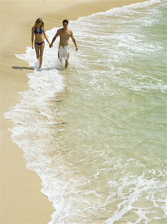 simsearch:640-02766382,k - Vue grand angle sur un jeune couple, main dans la main et en marchant sur la plage Photographie de stock - Premium Libres de Droits, Code: 640-02766300