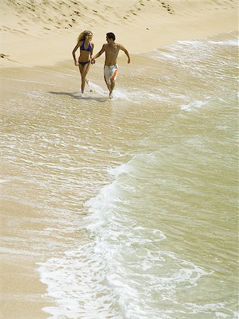 simsearch:640-01366190,k - High angle view of a young couple holding hands and running on the beach Foto de stock - Sin royalties Premium, Código: 640-02766303