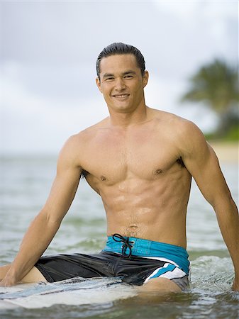 simsearch:640-01366190,k - Portrait of a young man sitting on a surfboard Foto de stock - Sin royalties Premium, Código: 640-02766388