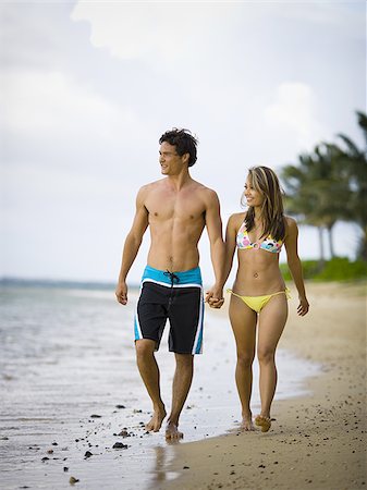 Young couple holding hands and walking on the beach Stock Photo - Premium Royalty-Free, Code: 640-02766382