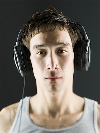 Close-up of a young man with headphones on Stock Photo - Premium Royalty-Free, Code: 640-02766435