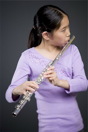 simsearch:640-03257223,k - Gros plan d'une jeune fille jouant de la flûte Photographie de stock - Premium Libres de Droits, Code: 640-02766460