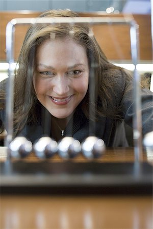 pendolo - Close-up of a businesswoman looking at a pendulum Fotografie stock - Premium Royalty-Free, Codice: 640-02766485