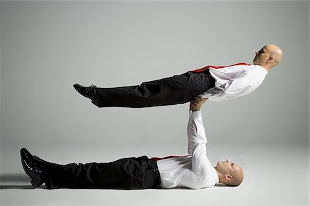 simsearch:640-02764552,k - Profile of two male acrobats in business suits performing Foto de stock - Royalty Free Premium, Número: 640-02766645