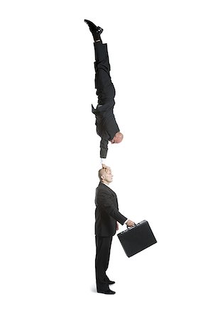 person on a trapeze - Profile of two male acrobats in business suits performing Stock Photo - Premium Royalty-Free, Code: 640-02766662