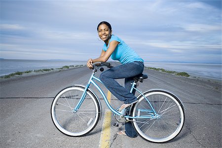 simsearch:640-02948353,k - Portrait of a young woman sitting on a bicycle Foto de stock - Royalty Free Premium, Número: 640-02766735