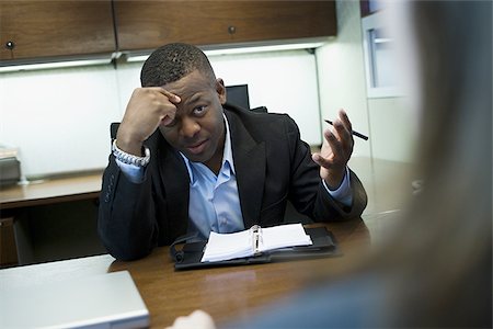 Close-up of a businessman discussing with his colleague Stock Photo - Premium Royalty-Free, Code: 640-02766754