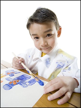 Portrait of a boy painting with a paintbrush Stock Photo - Premium Royalty-Free, Code: 640-02766781