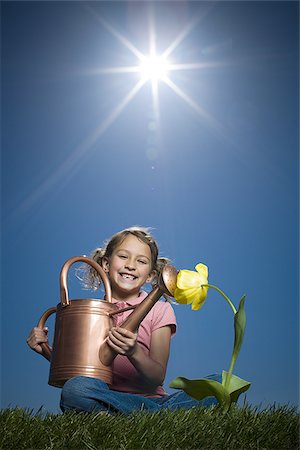 Portrait of a girl sitting beside a watering can Stock Photo - Premium Royalty-Free, Code: 640-02767009